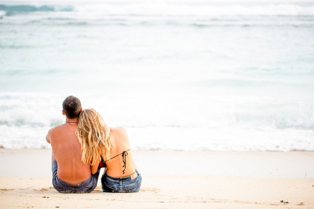 rear-view-of-happy-couple-sitting-on-seashore_1262-3276.jpg
