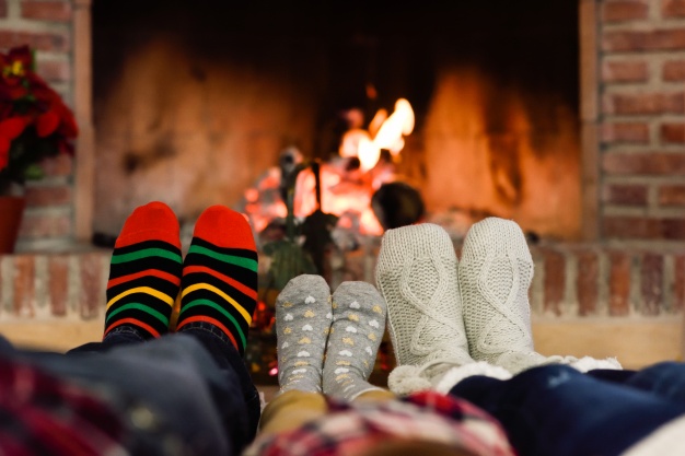 feet-christmas-socks-near-fireplace-relaxing-home_23-2147578351.jpg